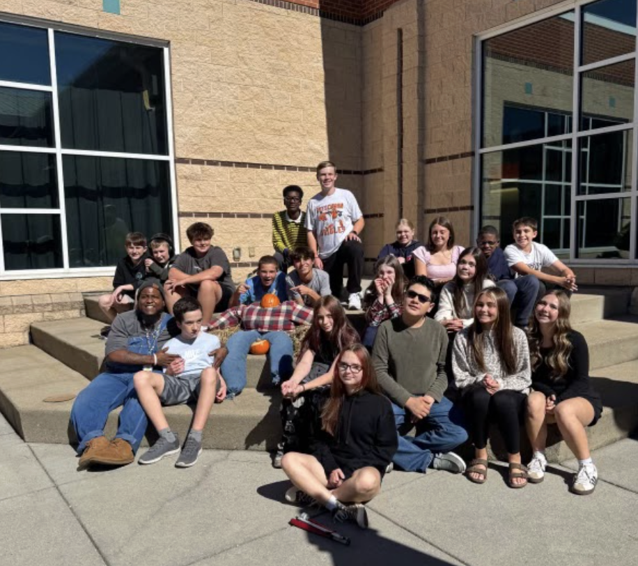Ms. Steeley's class group photo with scarecrow