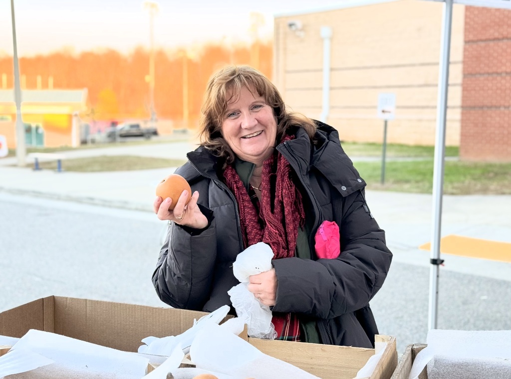 Person holding a pear smiling