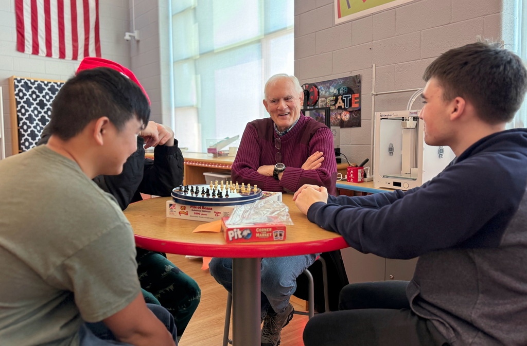 Students and a veteran laughing while playing a game