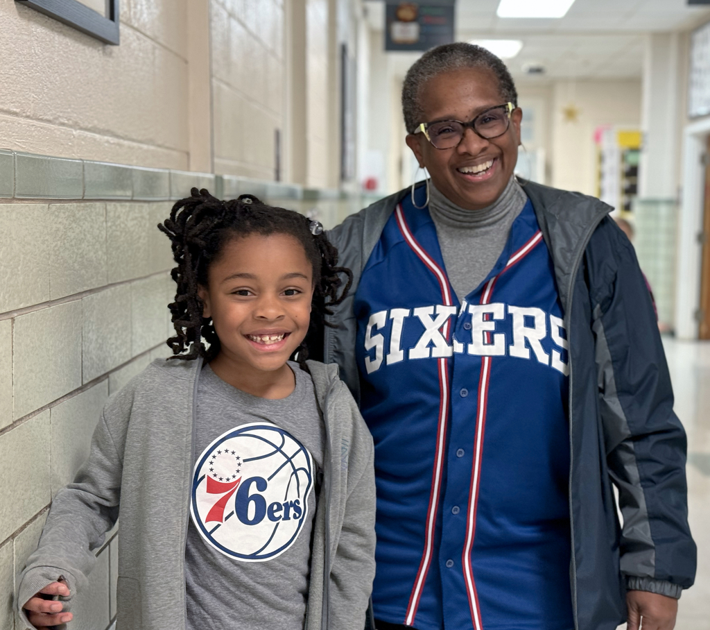 Two people smiling wearing ‘76ers shirts