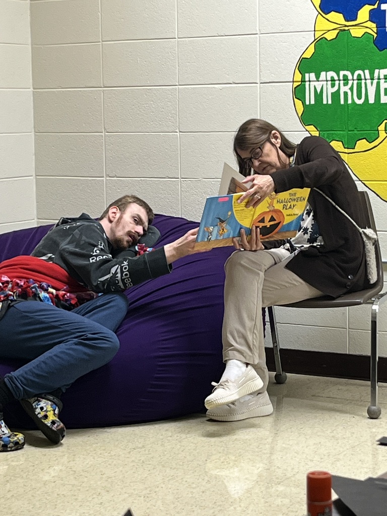 E and Mrs. Podner reading a book.