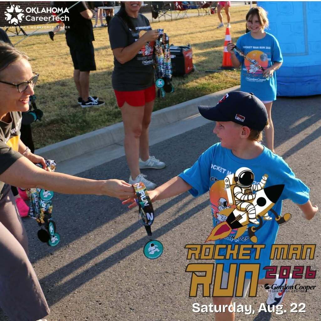 Young runner receives medal at finish line of 2025 Rocket Man Run.  