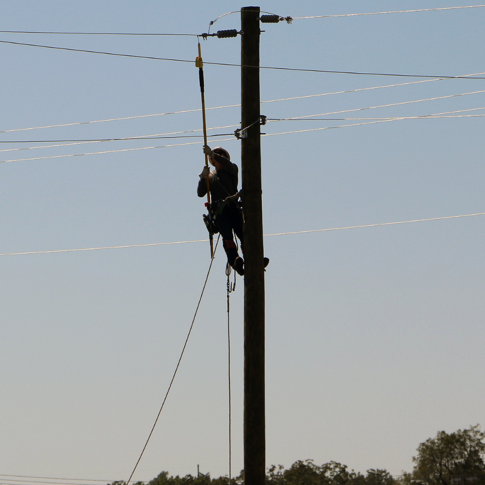 A student in the GCTC Lineworker Training program climbs a pole