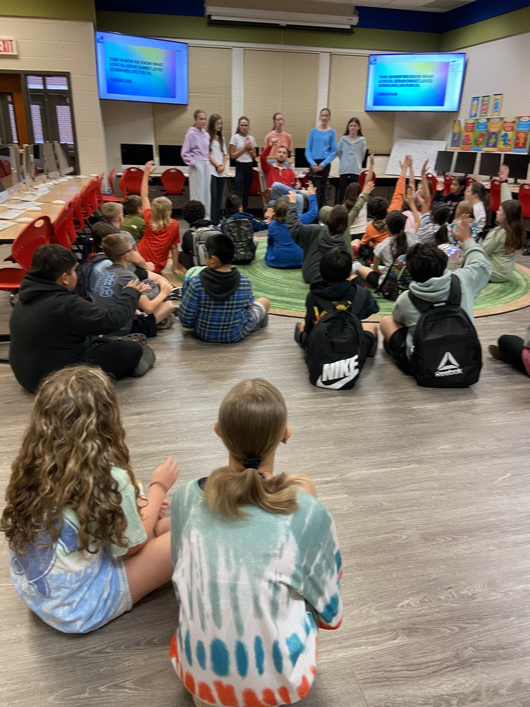 Group of children listening to adult speak