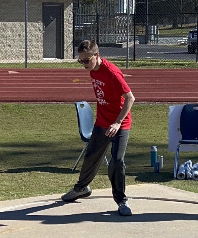 One boy in a red shirt throwing a ball.