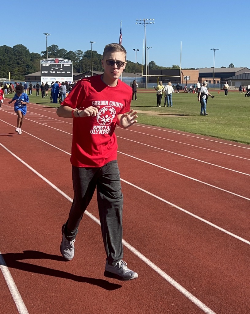 One boy in a red shirt running on a track