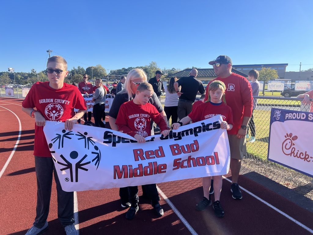 A group of students standing with a special olympics sign