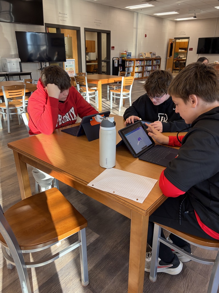 Three boys sitting around a table.