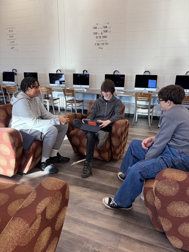 Three boys sitting in chairs.