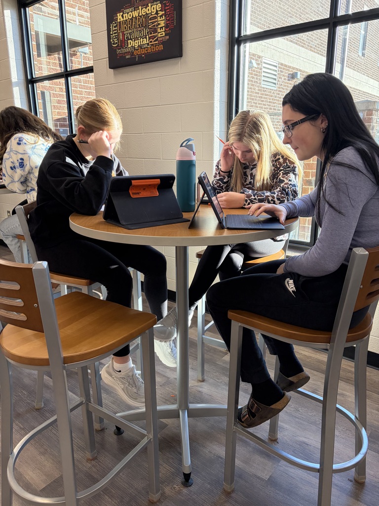 Three girls writing poetry.