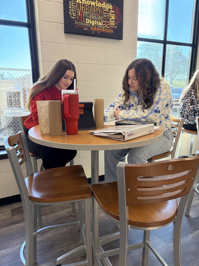 Two girls sitting at a table.