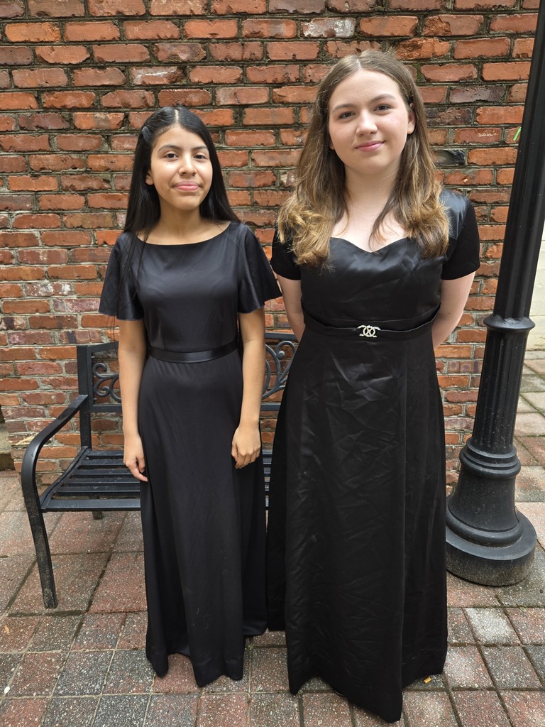 Two girls wearing long black dresses