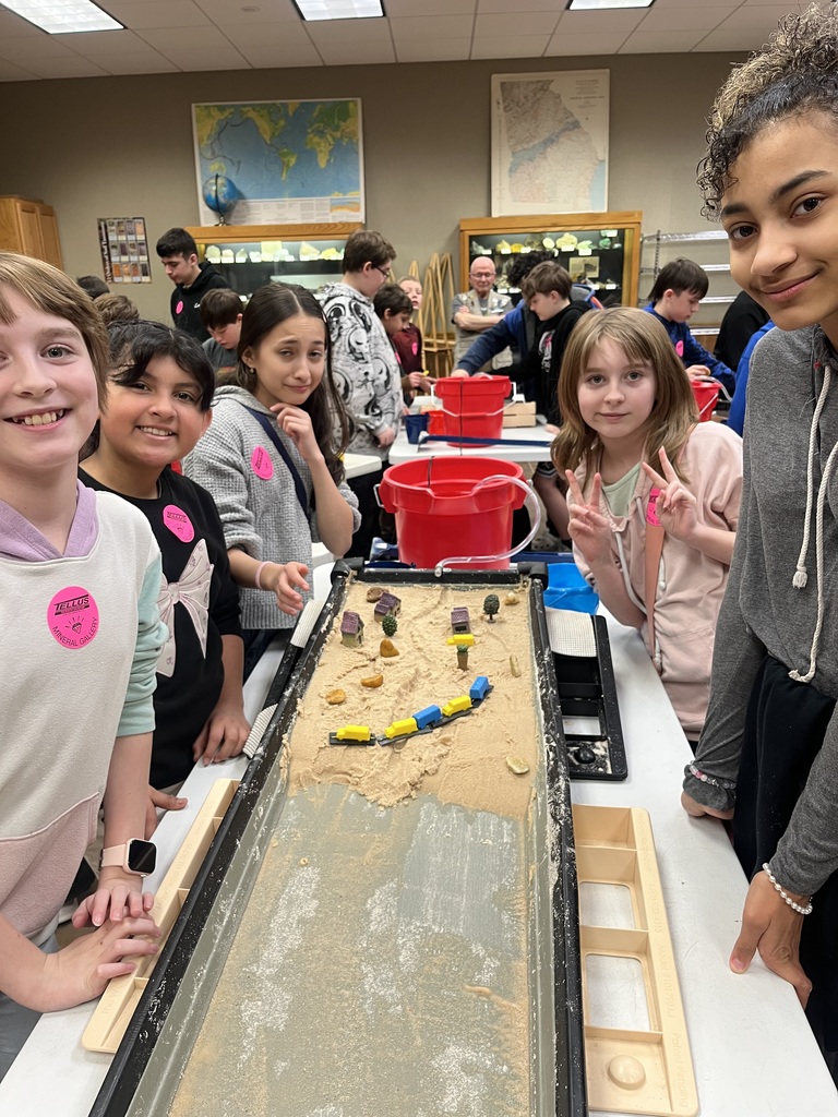 students creating erosion simulation in sand