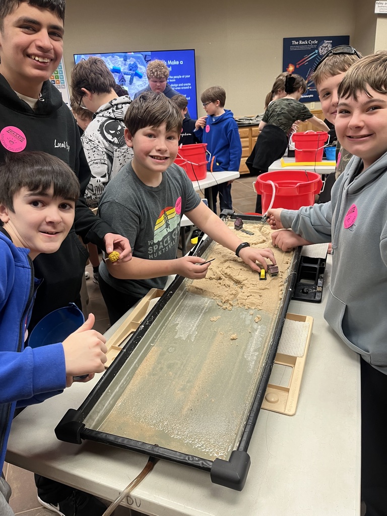 students creating erosion simulation in sand