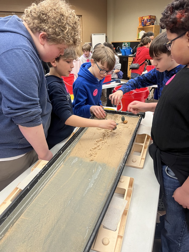 students creating erosion simulation in sand