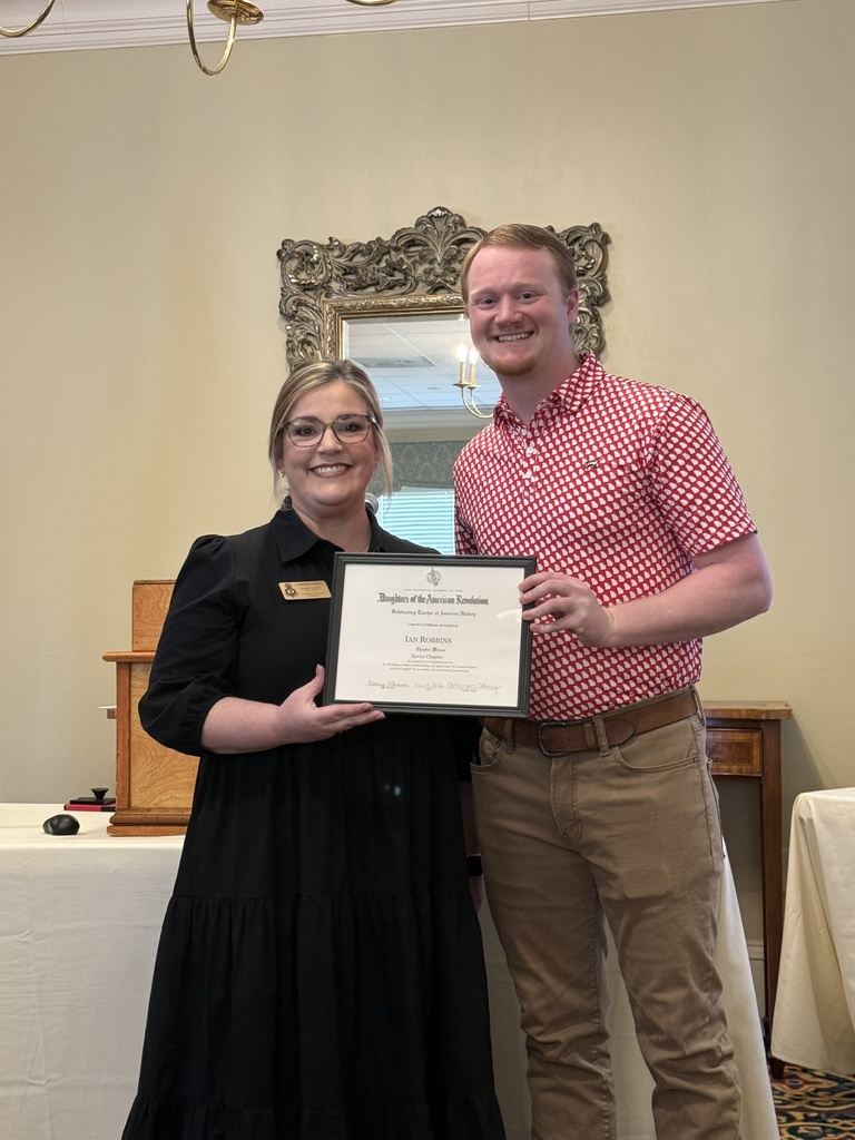 A member of the Daughter's of American Revolution presenting an award to Ian Robbins.