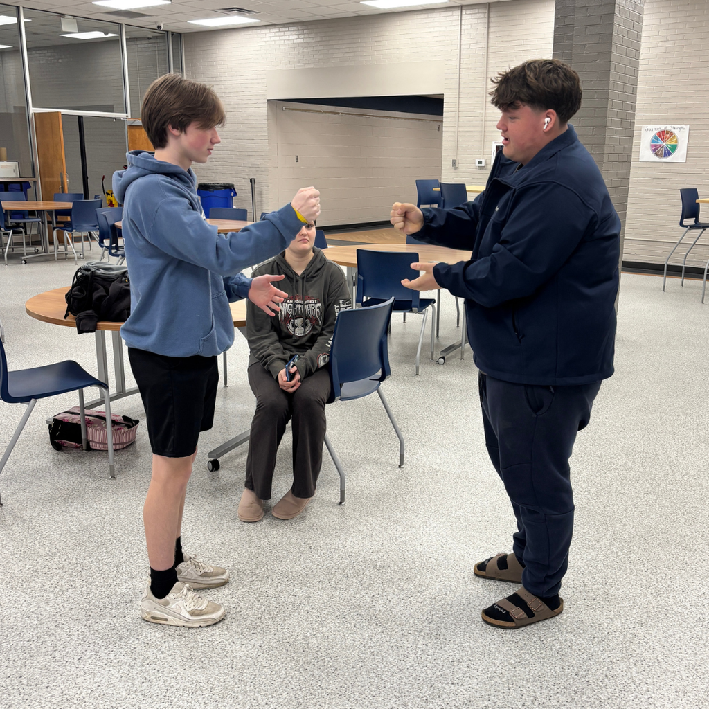 A group of two students playing Rock, Paper, Scissors for March Madness