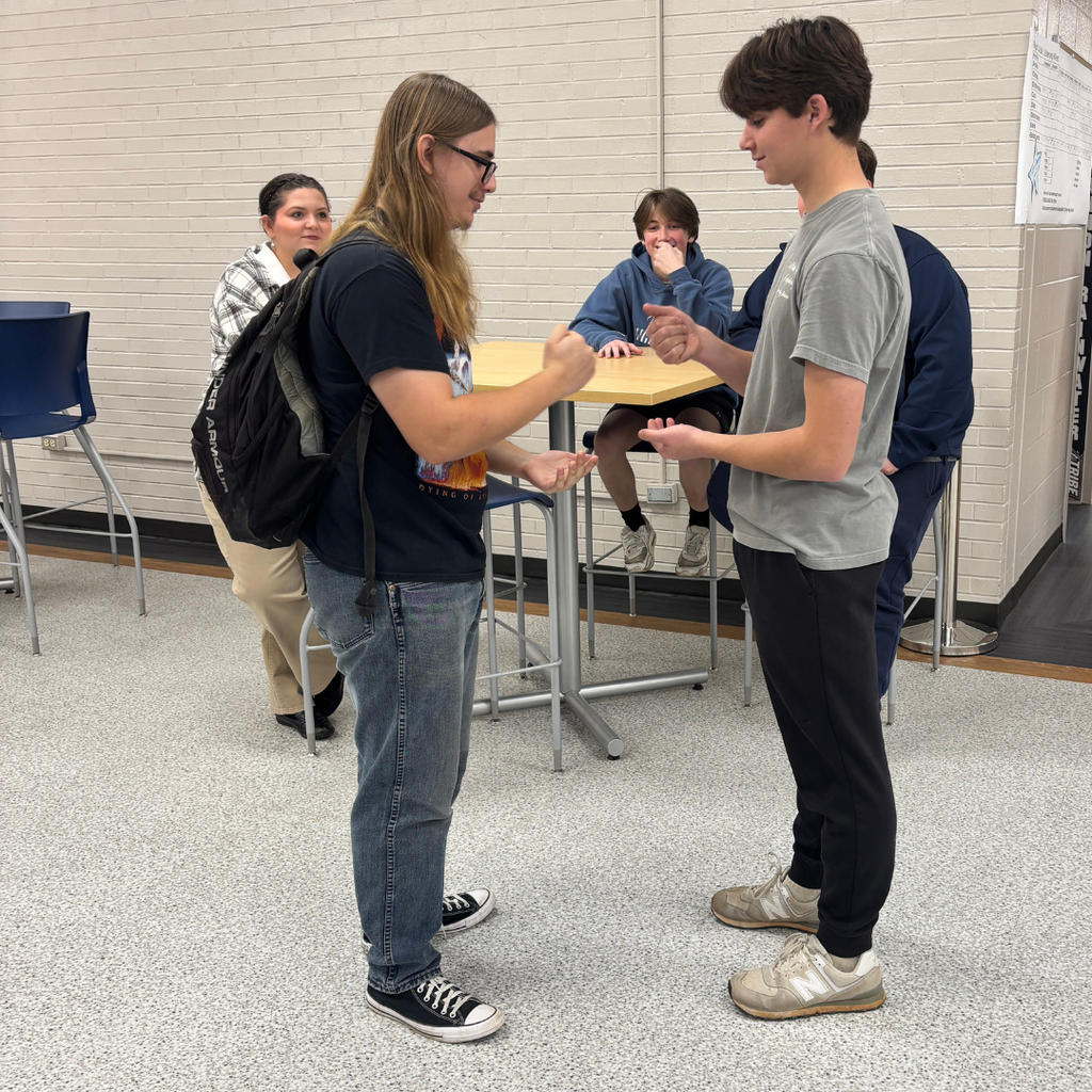 A group of two students playing Rock, Paper, Scissors for March Madness