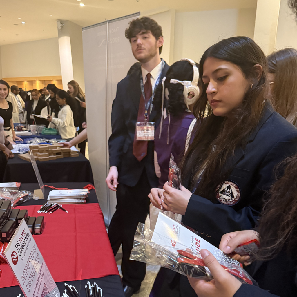 HOSA students receiving information at conference exhibit. 