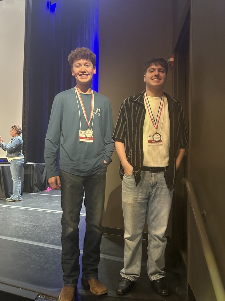 Two boys standing with 2nd place medals around their necks.