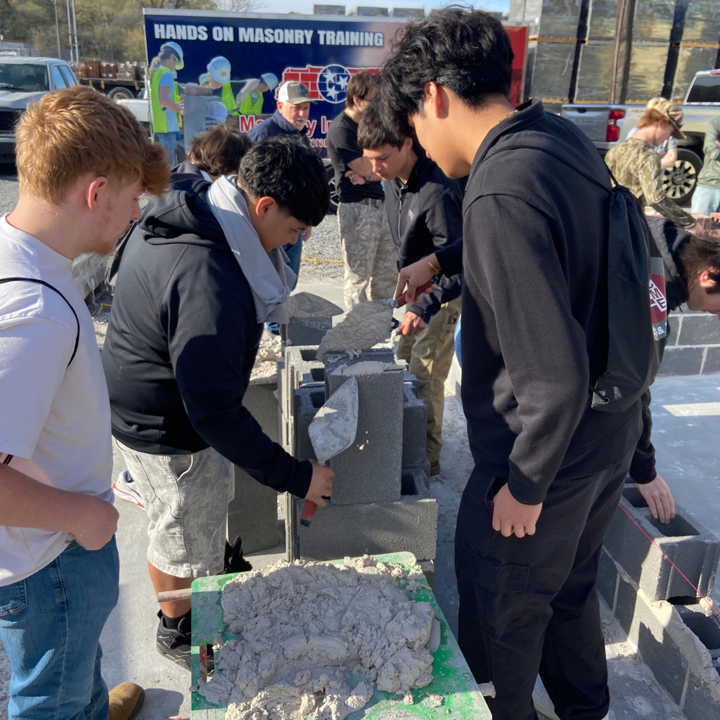 CTAE students working with concrete blocks and masonry onsite at field trip.