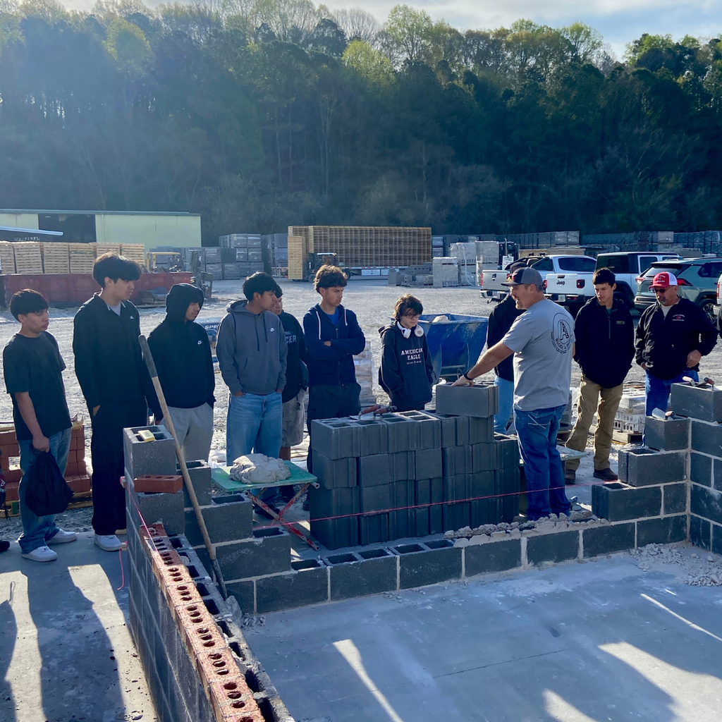 CTAE students watching demonstration of masonry techniques.