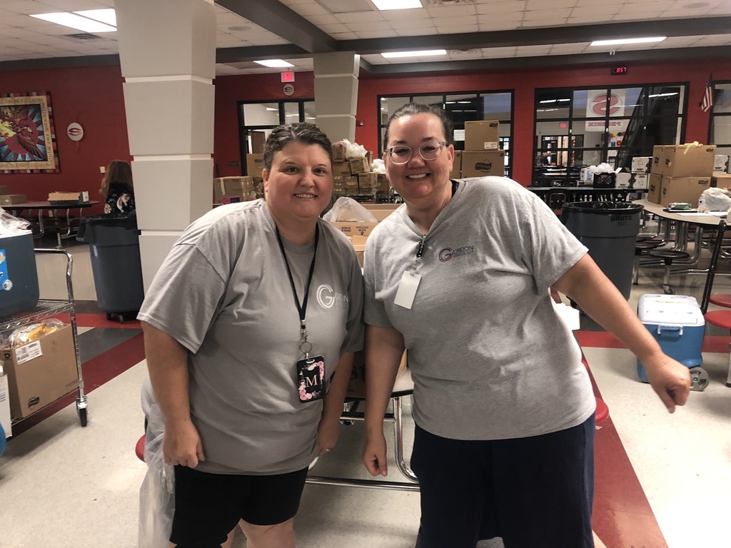 Two Summer Feeding Program workers in front of boxes and coolers.