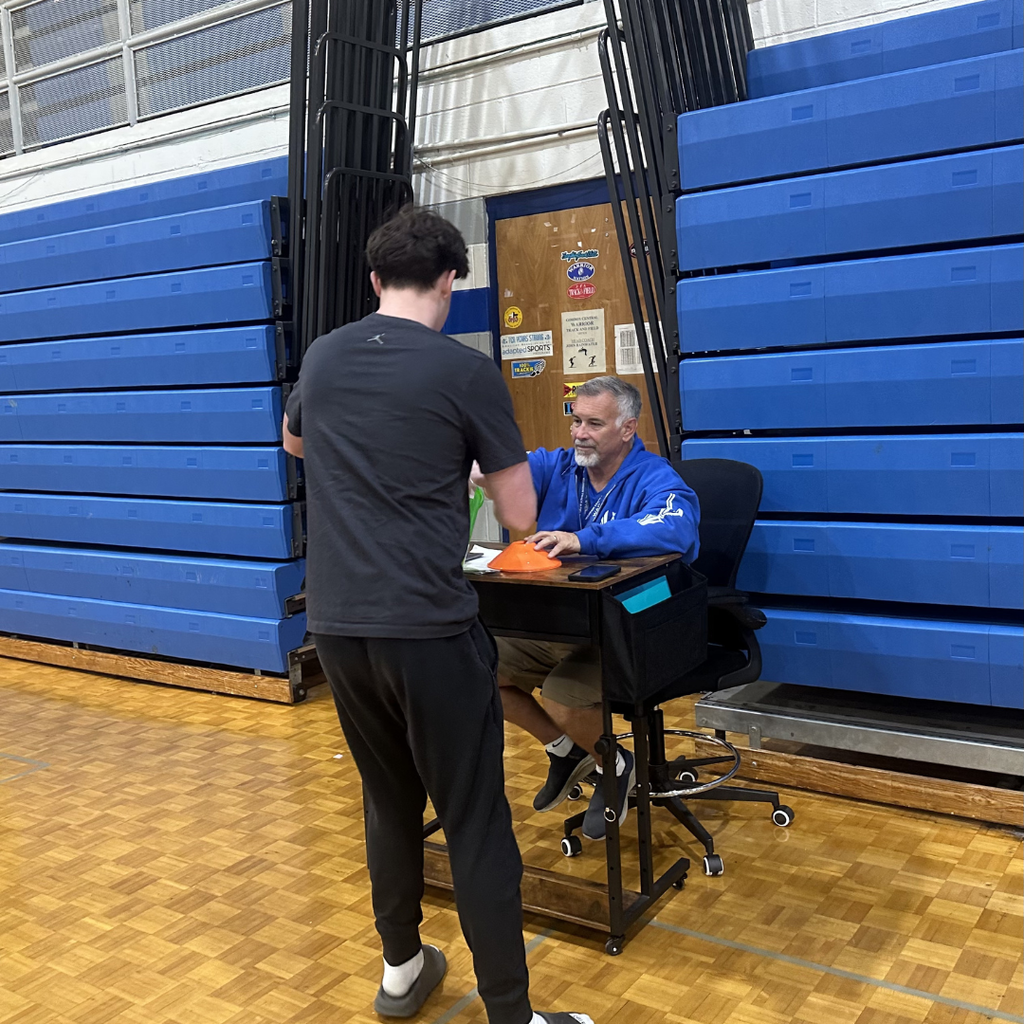 Grade level rep picking up scavenger hunt item from gym