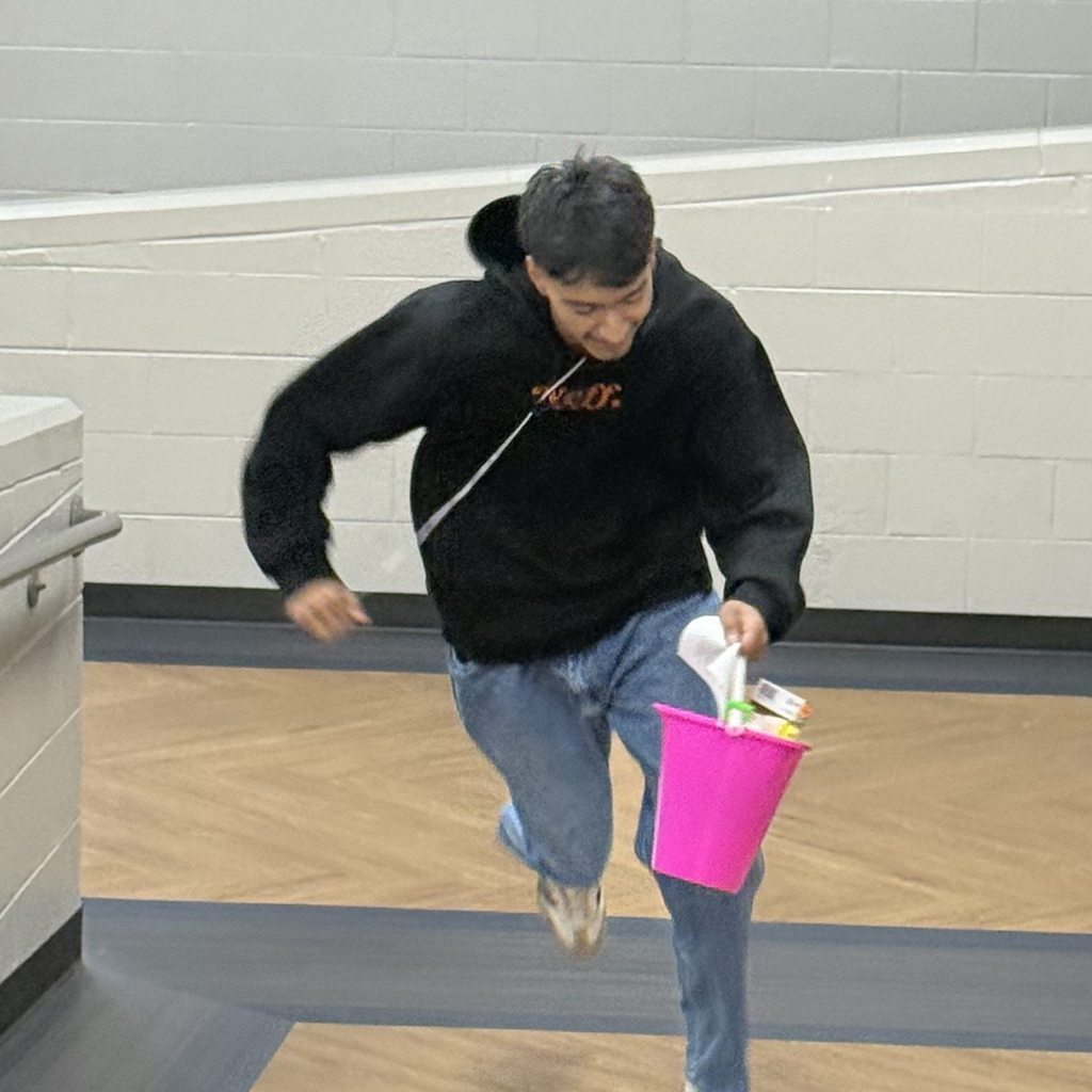Grade level competitor running down the hall with their scavenger hunt bucket