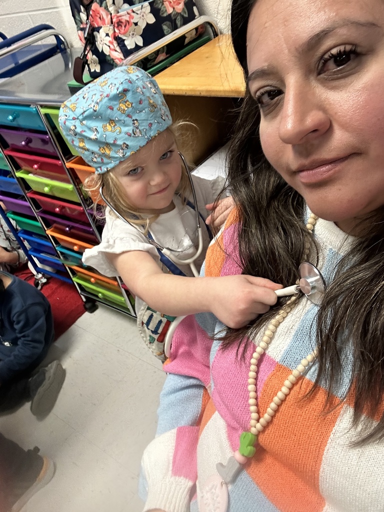 A candid moment of a paraprofessional interacting with students, showing patience and care while supporting their learning.