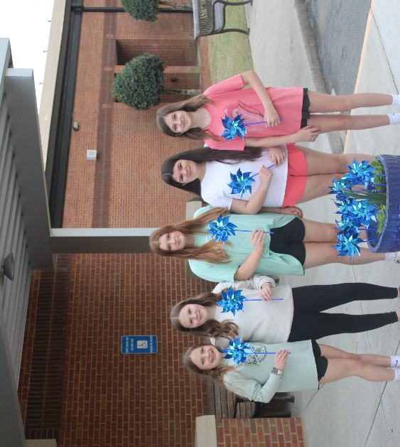 students planting pinwheels in honor of child abuse prevention awareness month