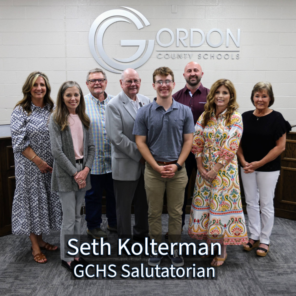 GCHS Salutatorian Seth Kolterman with GCS Board of Education members in front of a Gordon County Schools logo
