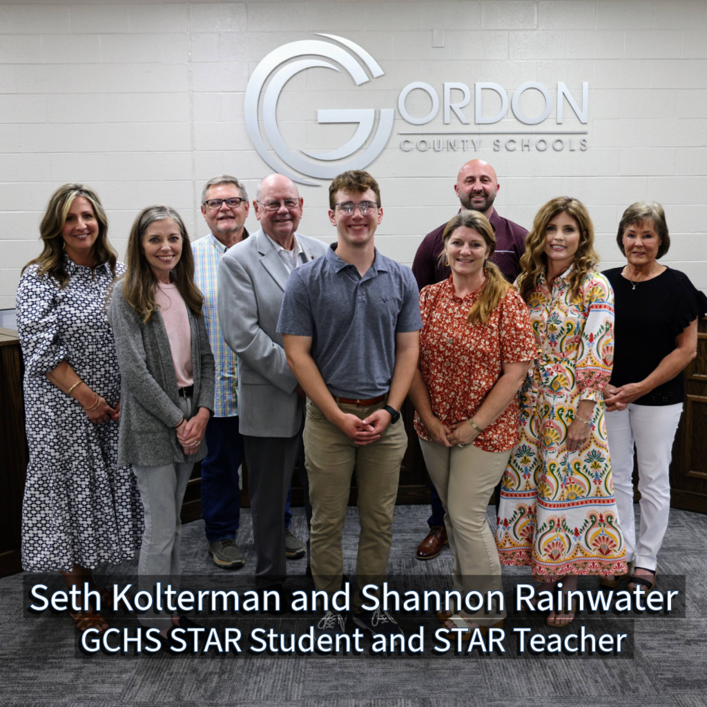 GCHS STAR Student and STAR Teacher Seth Kolterman and Shannon Rainwater with GCS Board of Education members in front of a Gordon County Schools logo