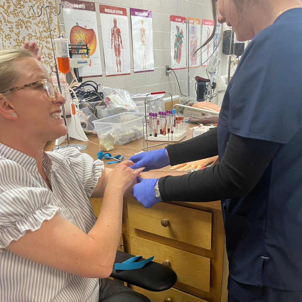 Allied Health student practicing venipuncture & capillary sticks with Mrs. Daina Patterson - licensed phlebotomist and GC staff member