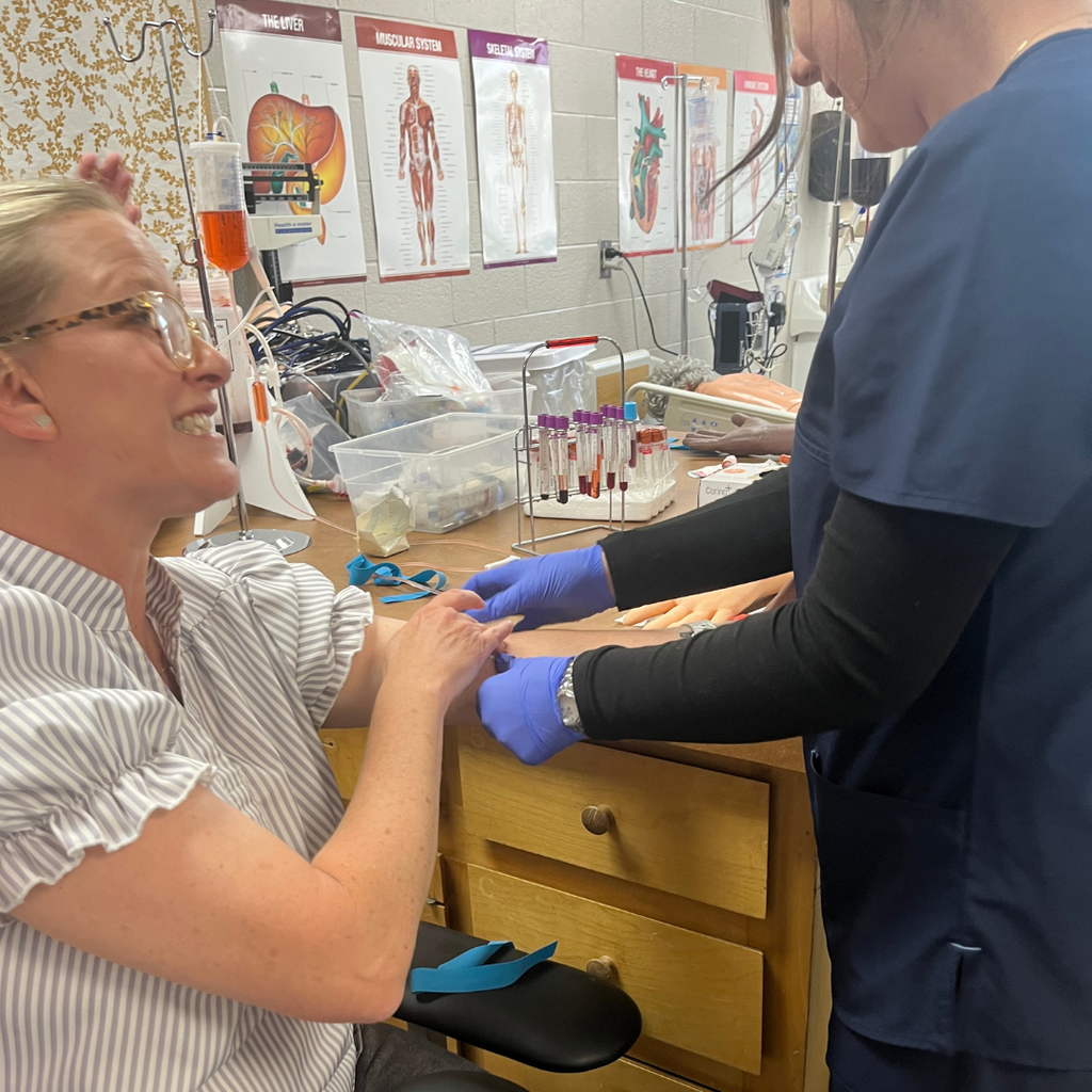 Allied Health student practicing venipuncture & capillary sticks with Mrs. Daina Patterson - licensed phlebotomist and GC staff member