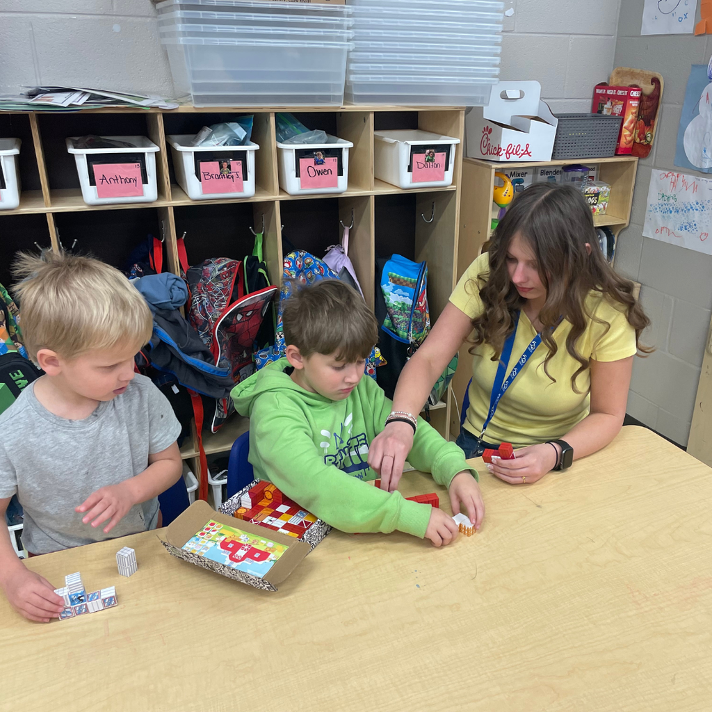 Pic of a GCHS Teaching as a Profession student in elementary classroom environment helping students