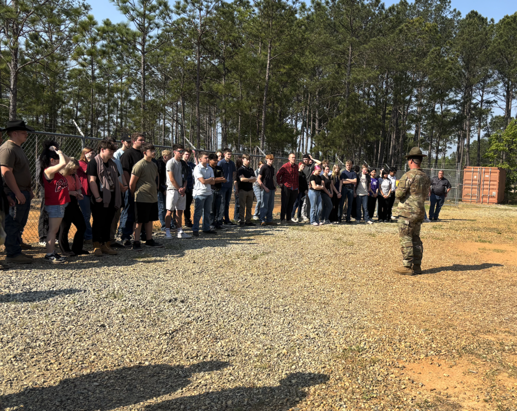 Drill sergeant speaking to cadets outside on a training course
