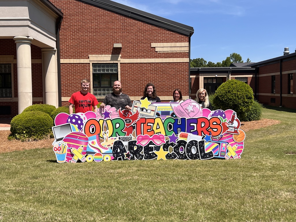 Specials Teachers standing behind a yard sign reading "our teaches are cool"