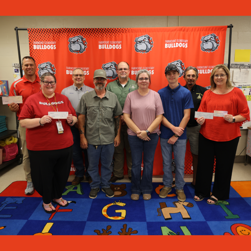 Community leaders and administrators at FES with donation checks