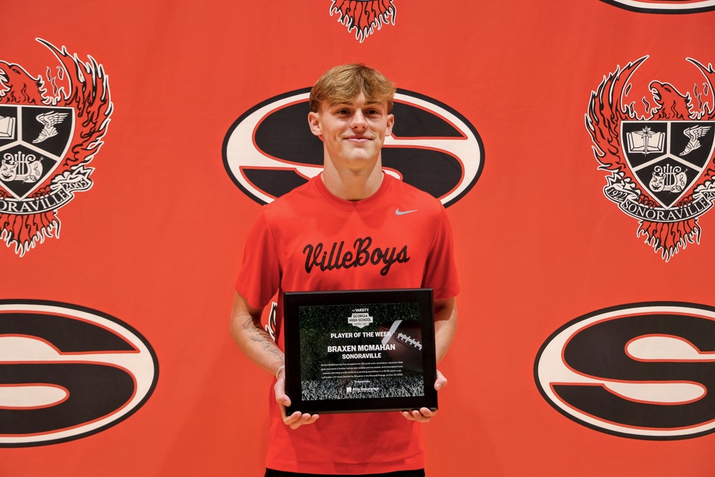 Ceremony honoring Braxen for winning state football player of the week. Posing with award