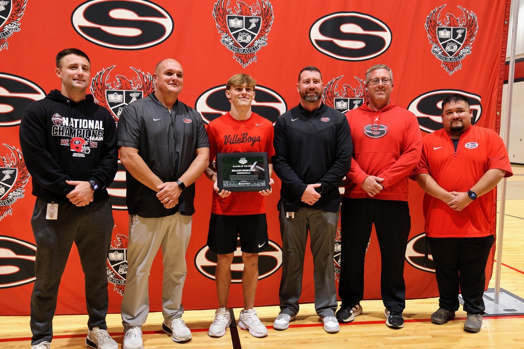 Ceremony honoring Braxen for winning state football player of the week. Posing with coaches