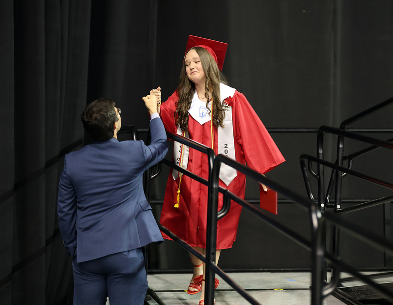 female in cap and gown greeting teacherreeting teacher