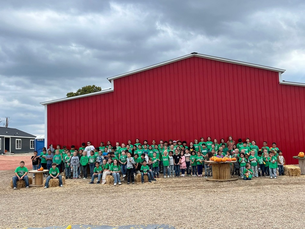 Elementary in front of a red barn