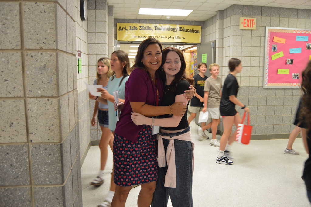 Woman hugging girl student