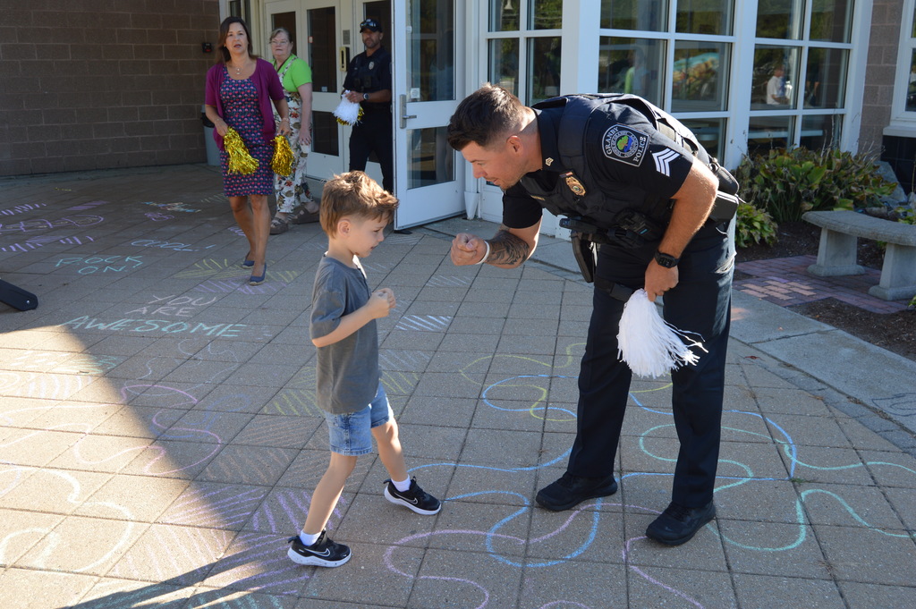 Police officer fist bumping young boy