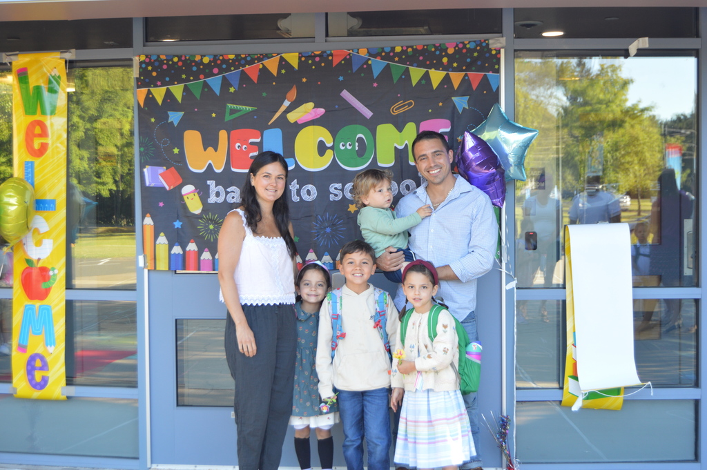 family with welcome back sign