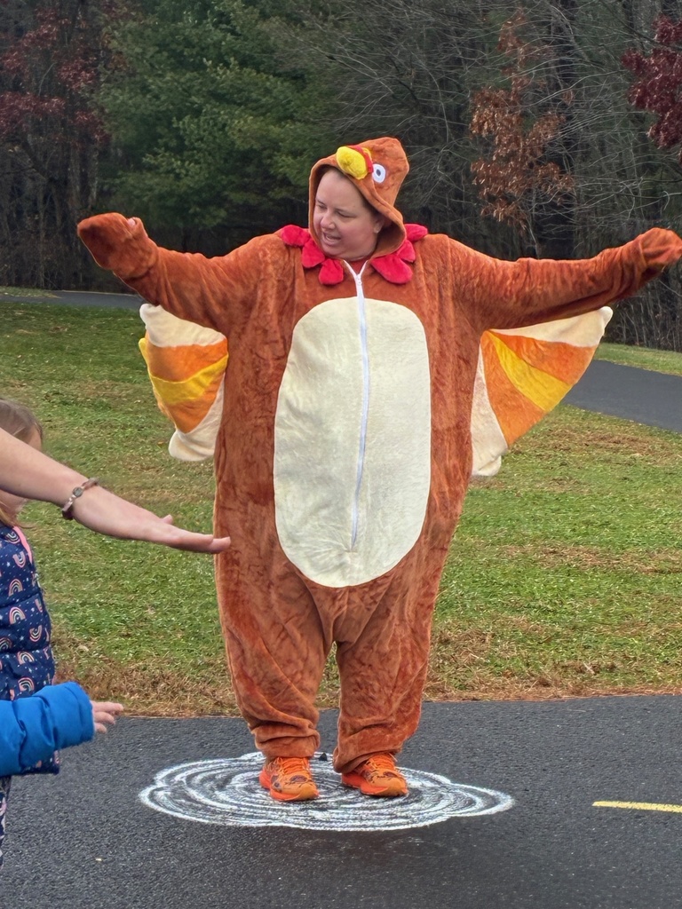 Ms. K dressed as a turkey doing warm up exercises with students
