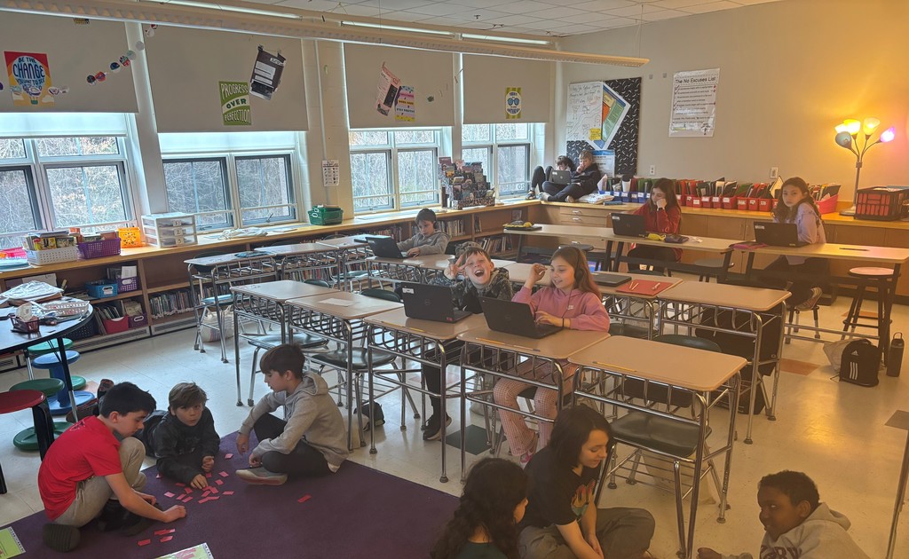 Students in groups doing work in classroom.