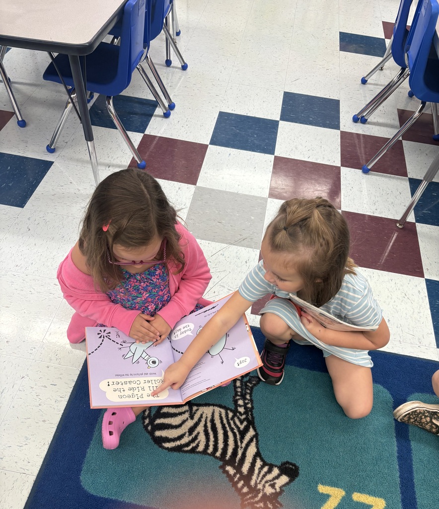 Two girls buddy reading.