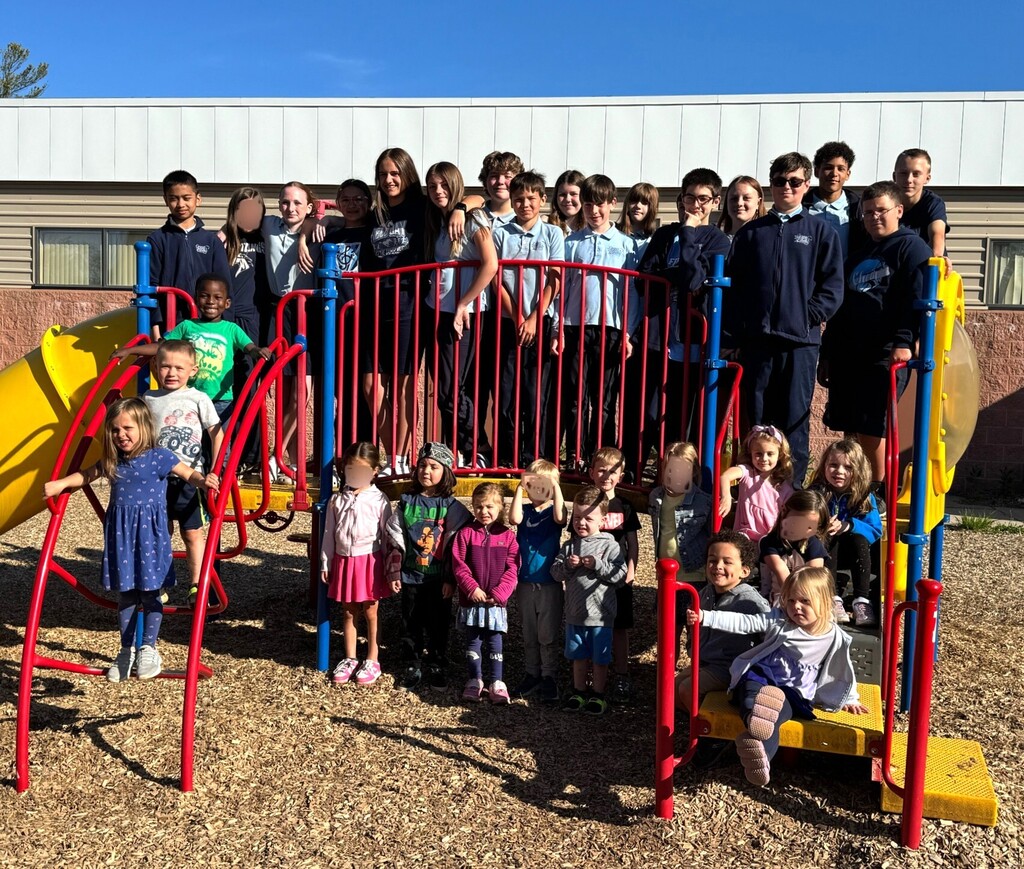 Preschool and 6th grade Book Buddies on the playground